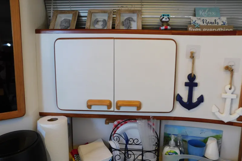 Slide: The Image of Interior of 1990 Sea Ray 350 Express Cruiser with nautical decor and kitchen essentials. - 56
