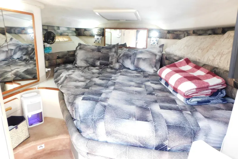 Slide: The Image of Interior cabin of 1990 Sea Ray 350 Express Cruiser with cozy bedding and blankets. - 31