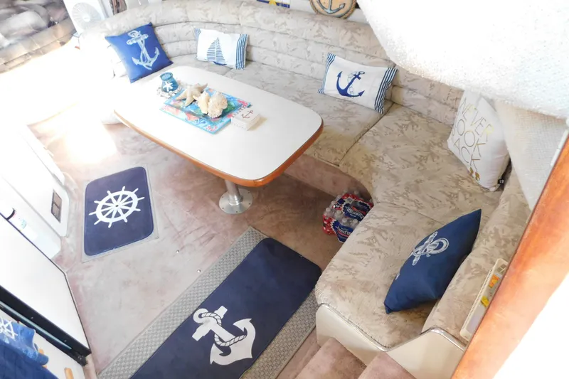 Slide: The Image of Interior of 1990 Sea Ray 350 Express Cruiser with nautical-themed decor and seating area. - 25