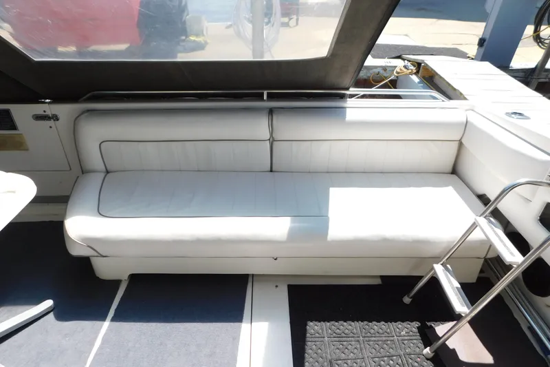 Slide: The Image of Interior seating of a 1990 Sea Ray 350 Express Cruiser with white upholstery. - 7