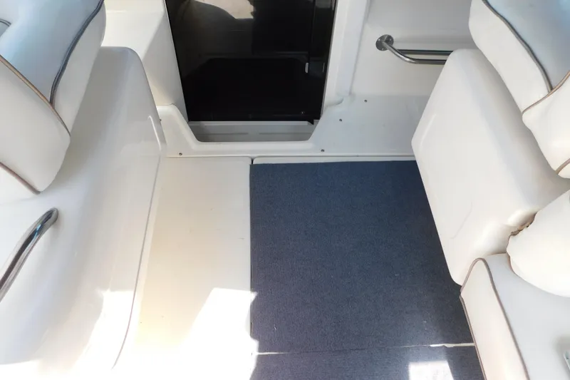 Slide: The Image of Interior of a 1990 Sea Ray 350 Express Cruiser with white seating and blue carpet. - 23