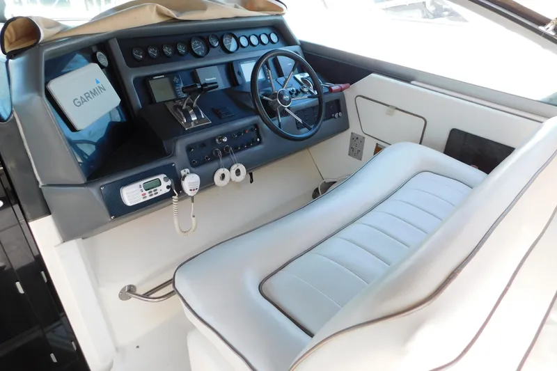 Slide: The Image of Cockpit of 1990 Sea Ray 350 Express Cruiser with Garmin navigation system and white seating. - 12