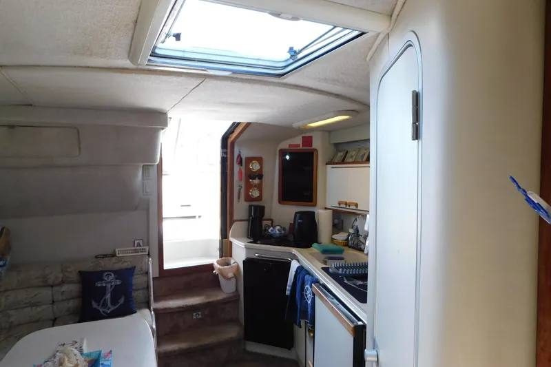 Slide: The Image of Interior of a 1990 Sea Ray 350 Express Cruiser with kitchenette and seating area. - 49