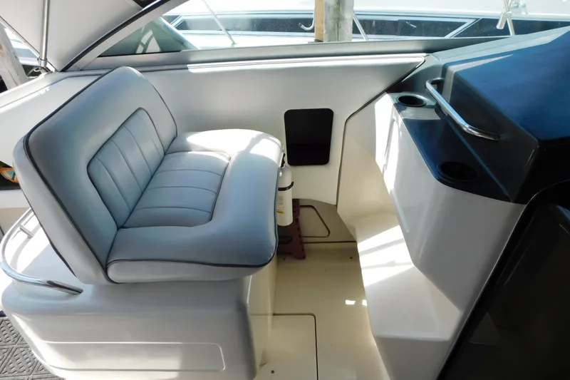 Slide: The Image of Interior seating of 1990 Sea Ray 350 Express Cruiser, featuring cushioned helm seat. - 19