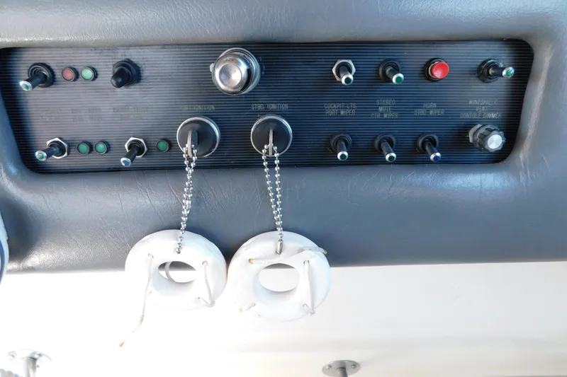 Slide: The Image of Control panel of a 1990 Sea Ray 350 Express Cruiser with switches and keychains. - 14