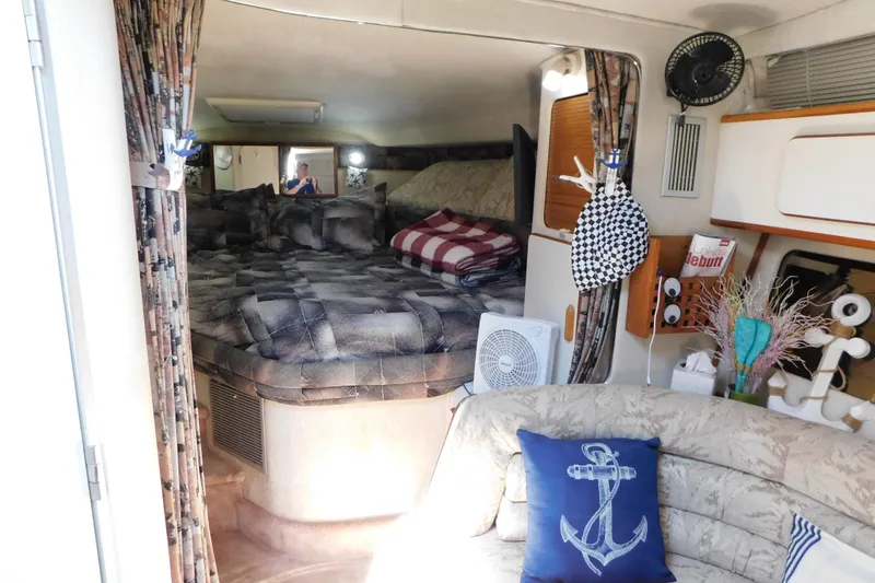 Slide: The Image of Cozy interior of 1990 Sea Ray 350 Express Cruiser with bed and nautical decor. - 30