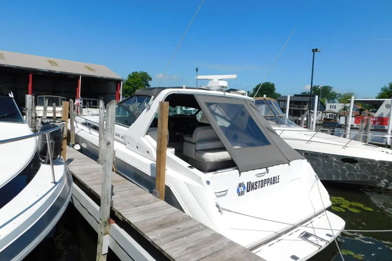 Slide: The Image of 1990 Sea Ray 350 Express Cruiser docked at marina under clear blue sky. - 2