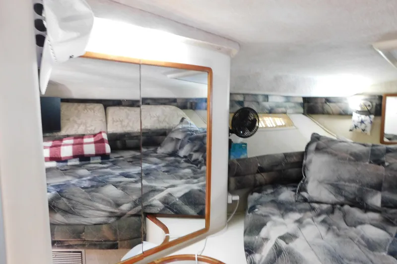 Slide: The Image of Interior of 1990 Sea Ray 350 Express Cruiser with cozy bedding and mirrored walls. - 33