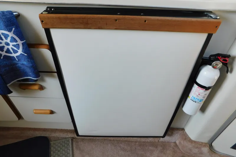 Slide: The Image of Interior of 1990 Sea Ray 350 Express Cruiser with fridge and fire extinguisher. - 51