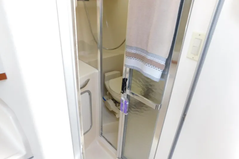 Slide: The Image of Bathroom interior of 1990 Sea Ray 350 Express Cruiser with shower and towel. - 42