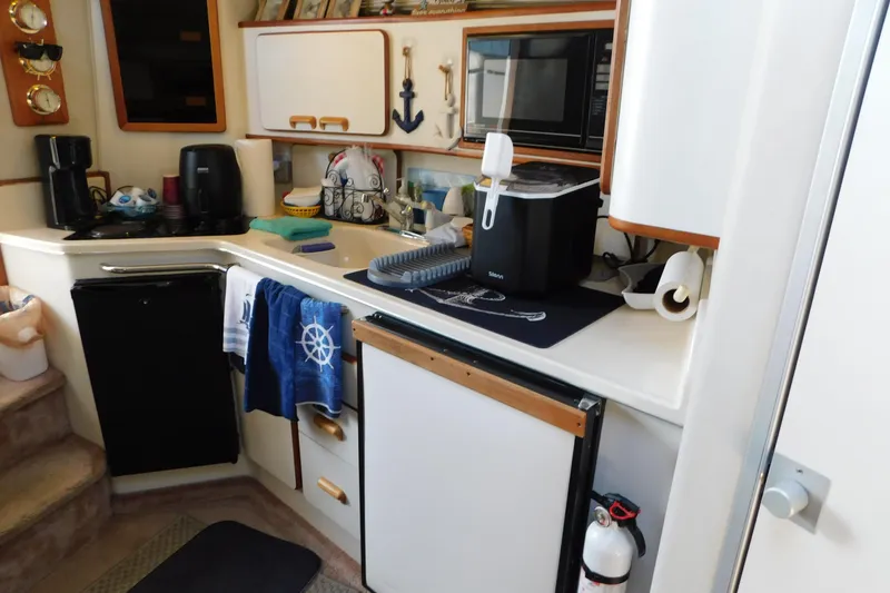 Slide: The Image of Interior of 1990 Sea Ray 350 Express Cruiser kitchen with appliances and nautical decor. - 50