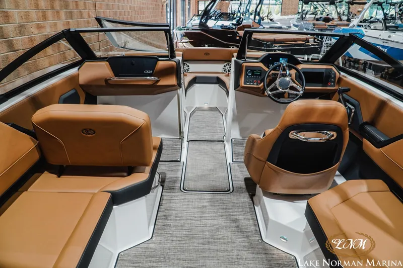 Slide: The Image of 2026 Cobalt CS23 boat interior with tan leather seats and modern dashboard at Lake Norman Marina. - 9