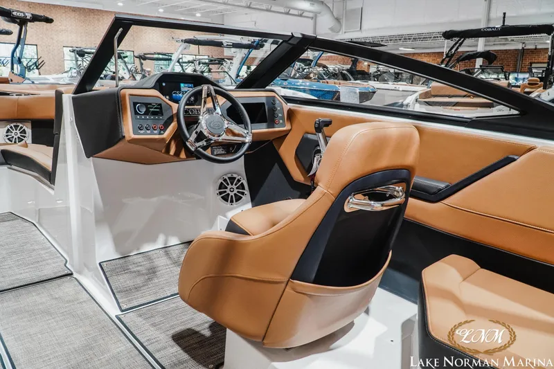 Slide: The Image of 2026 Cobalt CS23 boat interior with tan leather seats and modern dashboard at Lake Norman Marina. - 10