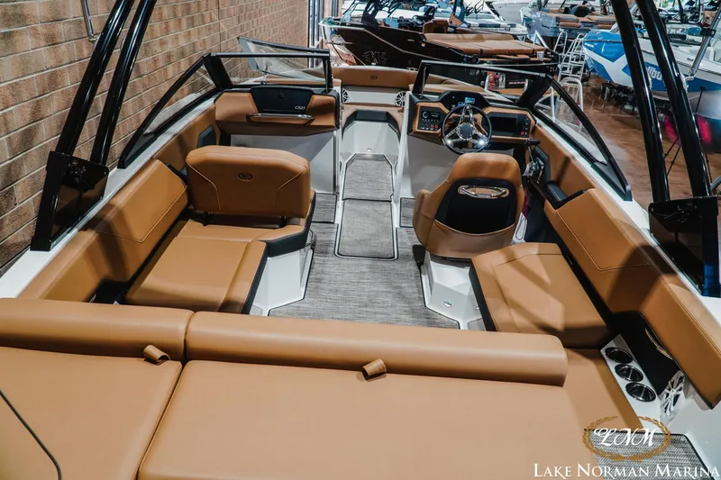 Slide: The Image of 2026 Cobalt CS23 boat interior with tan seating and modern dashboard at Lake Norman Marina. - 8