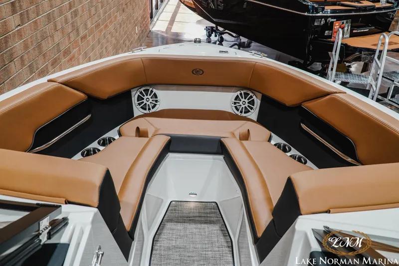 Slide: The Image of 2026 Cobalt CS23 boat interior with tan leather seating and cup holders at Lake Norman Marina. - 14