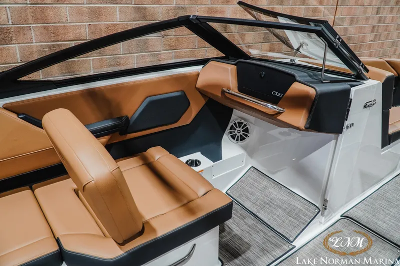 Slide: The Image of 2026 Cobalt CS23 boat interior with tan and black seating, modern dashboard, and speaker system. - 13
