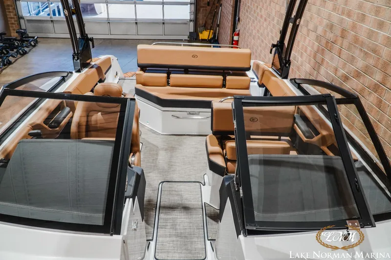 Slide: The Image of 2026 Cobalt R4 boat interior with tan seating, glass windshields, and modern design at Lake Norman Marina. - 19