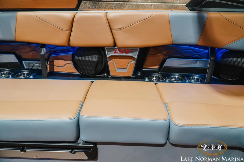 Slide: The Image of 2026 Malibu Wakesetter 23 LSV interior with tan and gray seating, cup holders, and LSV logo. - 23