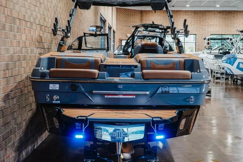 Slide: The Image of 2026 Malibu Wakesetter 23 LSV boat in showroom, rear view with sleek design and modern features. - 7