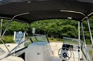 Slide: The Image of 2015 Grady-White Freedom 225 boat interior with canopy and steering wheel. - 24