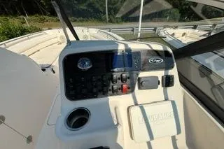 Slide: The Image of 2015 Grady-White Freedom 225 boat dashboard with controls and storage compartment. - 8