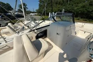 Slide: The Image of 2015 Grady-White Freedom 225 boat interior with seating and console, docked outdoors. - 6