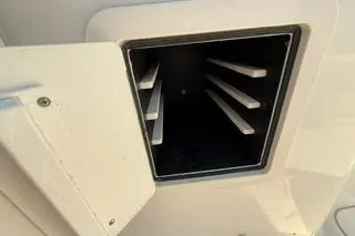 Slide: The Image of 2015 Grady-White Freedom 225 boat compartment with storage slots, open hatch view. - 18