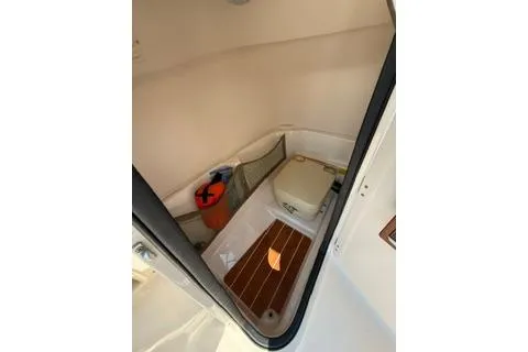 Slide: The Image of 2015 Grady-White Freedom 225 boat interior with compact cabin and wooden flooring. - 19