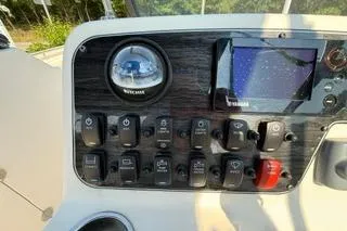 Slide: The Image of Control panel of 2015 Grady-White Freedom 225 boat with switches and navigation screen. - 13