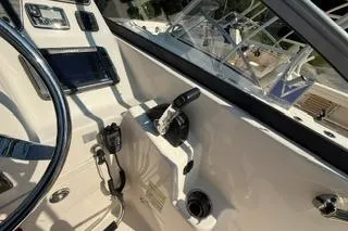 Slide: The Image of 2015 Grady-White Freedom 225 boat cockpit with steering wheel and controls. - 11