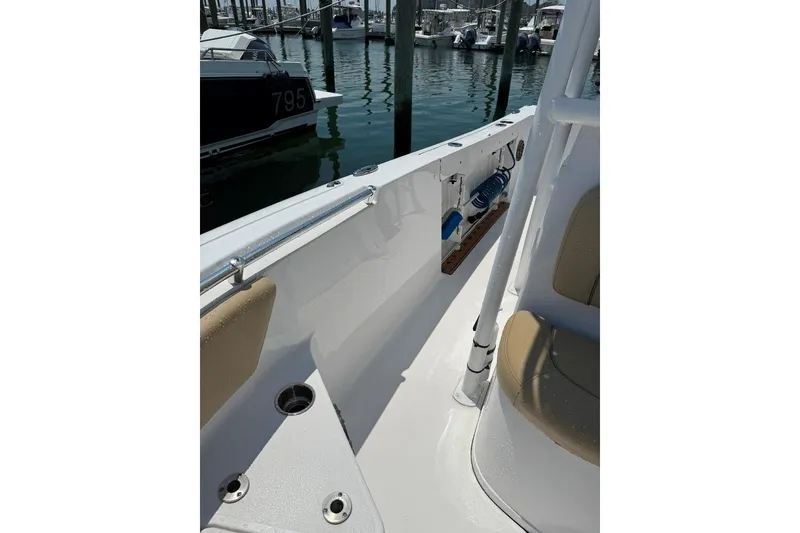 Slide: The Image of 2017 Sportsman Open 232 Center Console boat interior at marina, featuring seating and rod holders. - 18