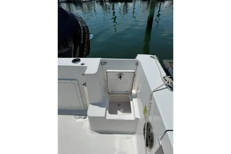 Slide: The Image of 2017 Sportsman Open 232 Center Console boat interior with storage compartment and Yamaha engine. - 24
