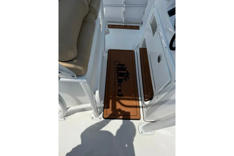 Slide: The Image of 2017 Sportsman Open 232 Center Console boat interior with cushioned seating and branded mat. - 30