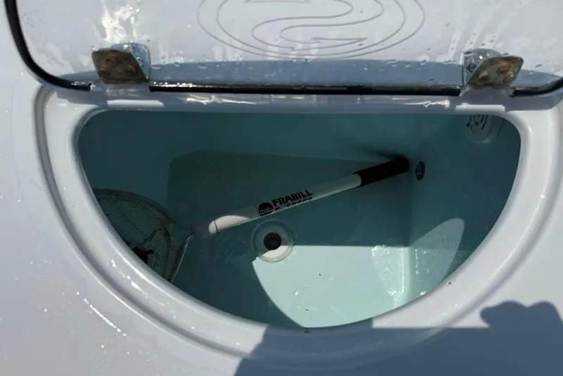 Slide: The Image of Livewell compartment in a 2017 Sportsman Open 232 Center Console boat with a Frabill net. - 35