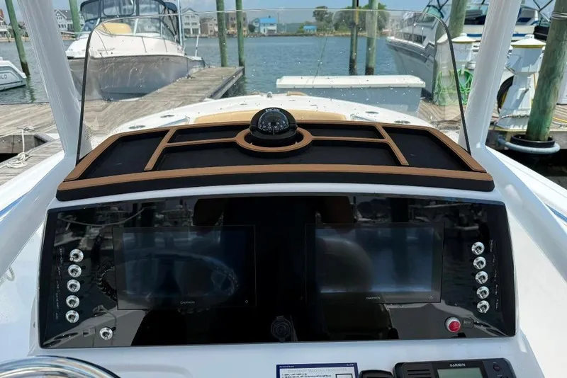 Slide: The Image of 2017 Sportsman Open 232 Center Console dashboard with navigation screens and compass at marina. - 27