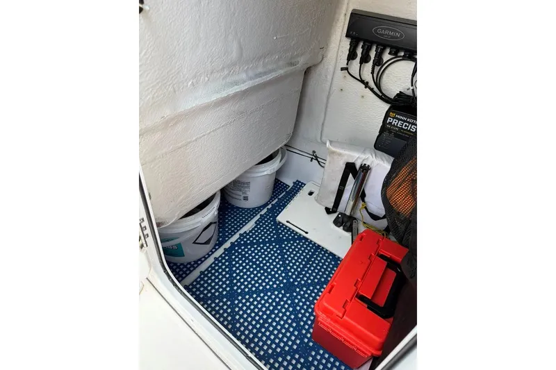 Slide: The Image of Storage compartment of a 2017 Sportsman Open 232 Center Console boat with equipment and supplies. - 42