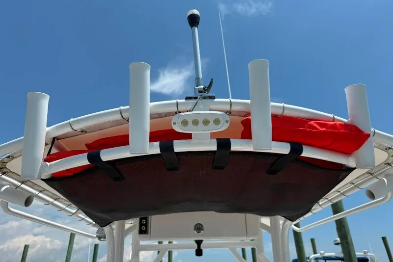Slide: The Image of 2017 Sportsman Open 232 Center Console boat with rod holders and storage, under clear sky. - 32