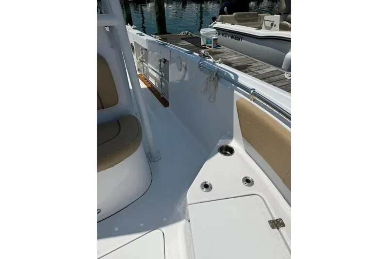 Slide: The Image of 2017 Sportsman Open 232 Center Console boat interior with seating and dock view. - 17