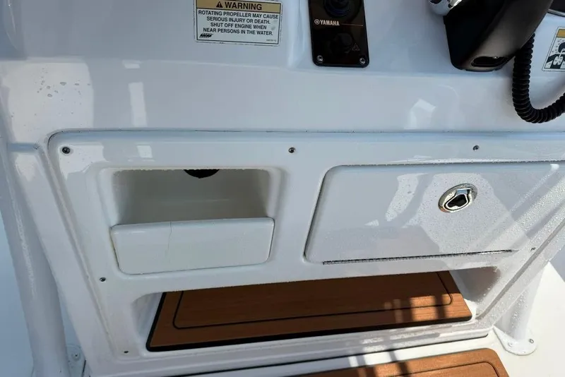 Slide: The Image of 2017 Sportsman Open 232 Center Console dashboard with storage compartments and warning label. - 29