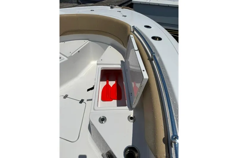 Slide: The Image of 2017 Sportsman Open 232 Center Console boat with open storage compartment and red paddles. - 20