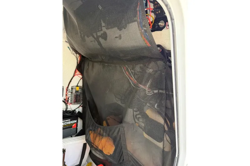 Slide: The Image of Interior view of a 2017 Sportsman Open 232 Center Console boat, showcasing wiring and storage. - 43