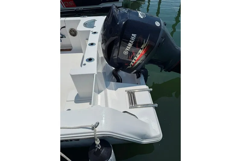 Slide: The Image of 2017 Sportsman Open 232 Center Console with Yamaha engine, docked on calm water. - 12