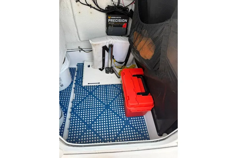 Slide: The Image of Interior of 2017 Sportsman Open 232 Center Console with red toolbox and blue mat. - 44