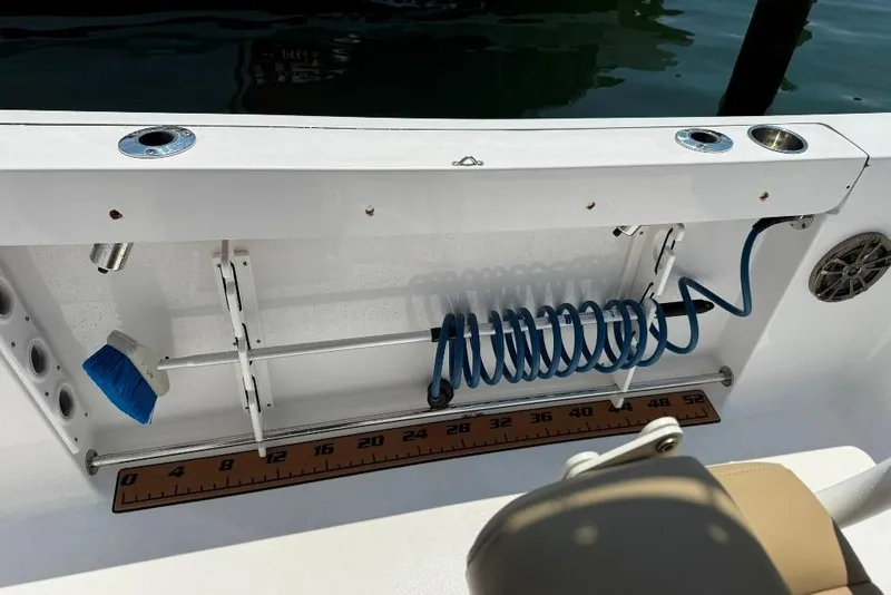 Slide: The Image of 2017 Sportsman Open 232 Center Console boat deck with coiled hose and measuring ruler. - 46