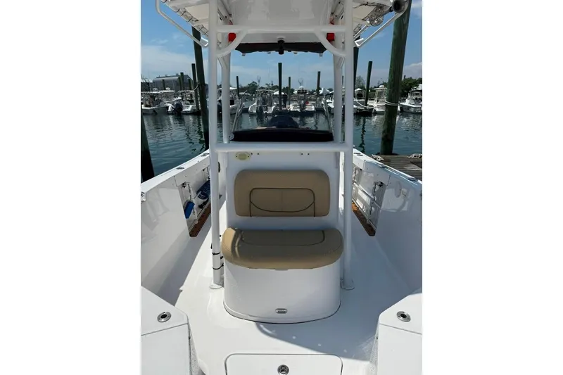 Slide: The Image of 2017 Sportsman Open 232 Center Console boat at marina, featuring beige seating and white deck. - 16