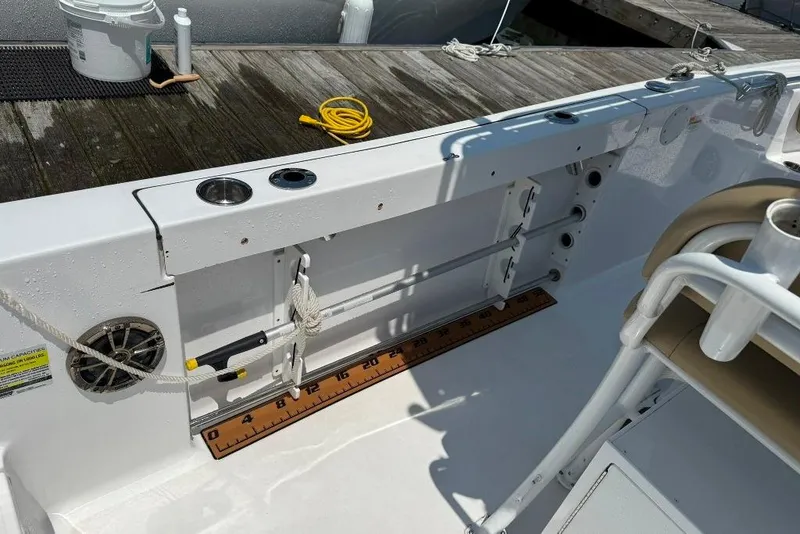 Slide: The Image of 2017 Sportsman Open 232 Center Console boat interior with fishing rod holders and measuring ruler. - 23
