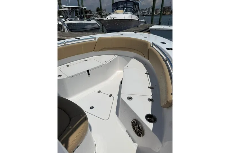 Slide: The Image of 2017 Sportsman Open 232 Center Console boat interior with cushioned seating and storage compartments. - 14
