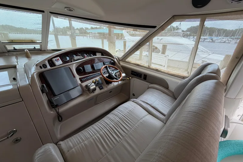 Slide: The Image of 2002 Sea Ray 480 Motor Yacht helm with leather seating and navigation controls. - 10