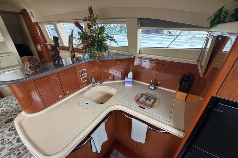Slide: The Image of Luxurious 2002 Sea Ray 480 Motor Yacht kitchen with elegant wood cabinetry and modern amenities. - 28