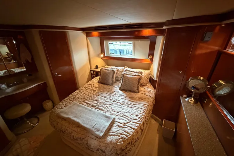 Slide: The Image of Luxurious 2002 Sea Ray 480 Motor Yacht bedroom with cozy bedding and elegant wood finishes. - 19